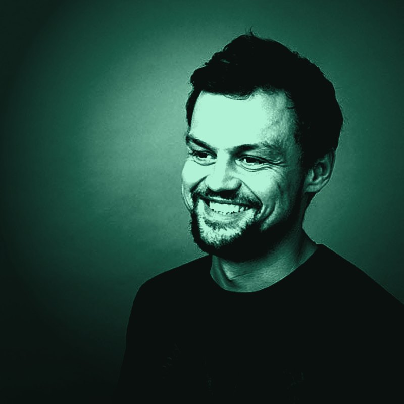 Wayne Gibbins, smiling, in a green-toned portrait